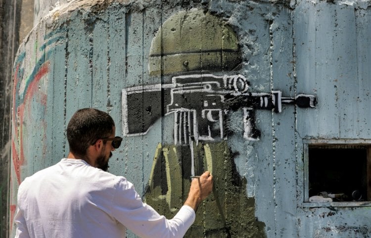 فنان فلسطيني يندد بالاحتلال من خلال رسوم غرافيتي على "الجدار" الإسرائيلي